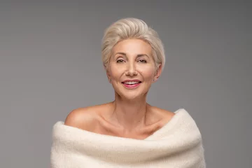 Wanddecoratie Schoonheidssalon Beautiful blonde caucasian middle aged woman with short hairstyle. Attractive lady with delicate makeup and smile wearing warm fashionable sweater  © neonshot