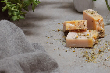 Detail shot of chamomile handmade soap bars and grey wool sweater. Room for text.