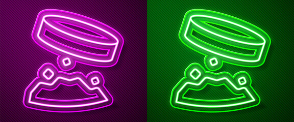 Glowing neon line Giant magnet holding iron dust icon isolated on purple and green background. Vector