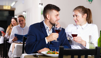 Gentleman with elegant woman are having dinner in luxury restaurante indoor.