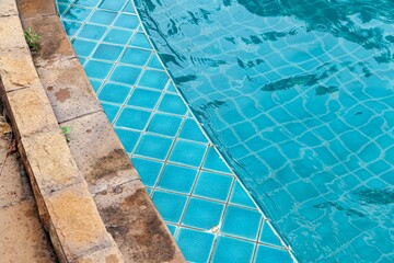 Wide swimming pool and brown wood floor inside the villa