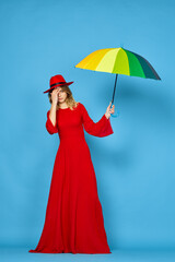 woman in red dress multicolored umbrella blue background