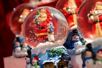 Santa Claus snowglobe set on a red velvet cloth sold at a booth of the Christmas market of the...