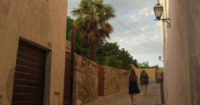 Two European Women Walking In A Picturesque Street Seen From Behind, KRK Croatia