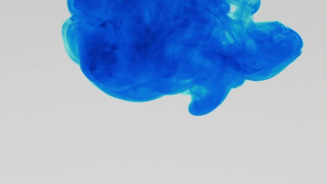 Blue pigment ink water explosion from above white background.