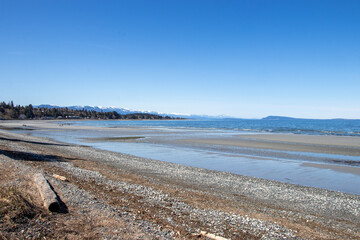 view of snow capped mountains from a beach on the pacific coast