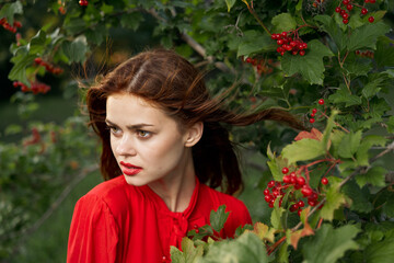 Naklejka premium pretty woman in red shirt nature green leaves summer