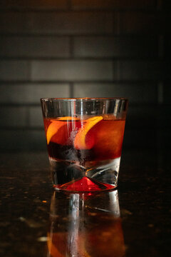 Negroni delicioso, bar escuro gelado, copo pequeno com laranja, casca e gelo