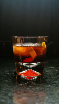 Negroni delicioso, bar escuro gelado, copo pequeno com laranja, casca e gelo
