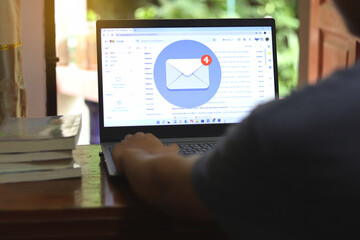 New email alert on laptop, communication connection message to global letters in the workplace.