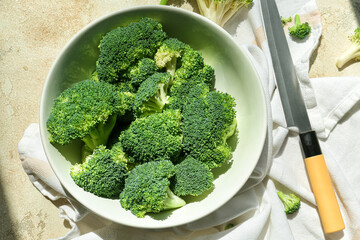 Bowl with healthy broccoli cabbage on light background