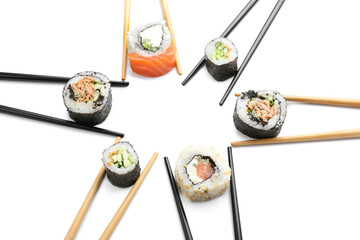 Chopsticks with tasty sushi rolls on white background