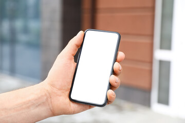 Male hand with modern mobile phone outdoors, closeup