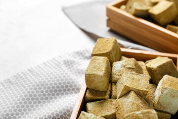 Wooden box with tasty hojicha marshmallows on light background, closeup
