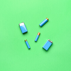 Alkaline batteries on green background, top view