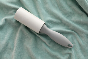 Lint roller on blue textile background