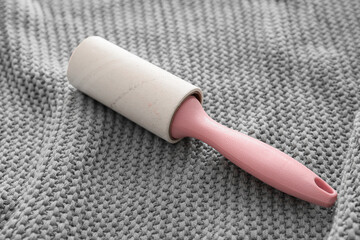Lint roller on grey textile background