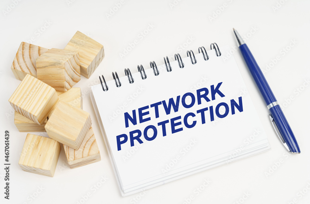 Poster on the table are cubes, a pen and a notebook with the inscription - network protection