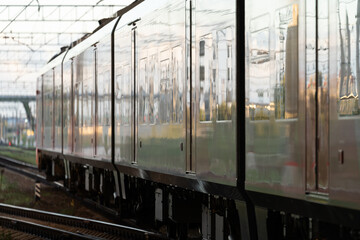 Train arrival: outside view of modern sleepers carriage for suburban or regional travel. Fast intercity locomotive on railroad. Wagon on railway. Transportation infrastructure and tourism concept