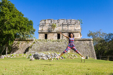 An adult woman jumps in the archeological park of Chichen Itza in Yucatan, Mexico
