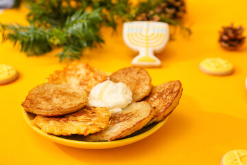 Latkes for Hanukkah celebration on color background