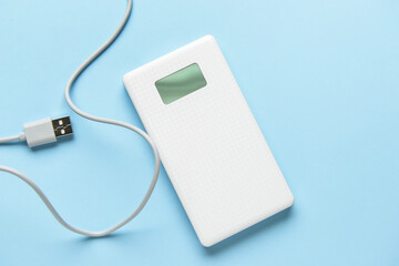 Obraz premium White Power Bank with USB Cable on Blue Background