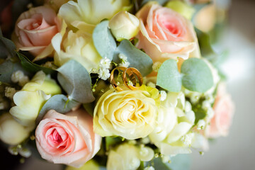 Obraz na płótnie Canvas Wedding rings on a petal of a rose. Concept for a wedding card. The bride's bouquet. High quality photo