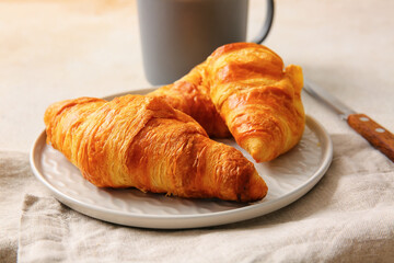 Plate with delicious croissants on white background