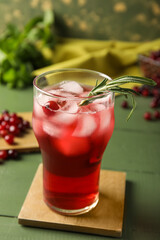 Glass with healthy cranberry juice on color wooden background