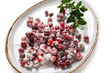 Plate with sugared cranberry on white background, closeup