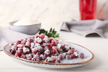 Plate with sugared cranberry on table, closeup