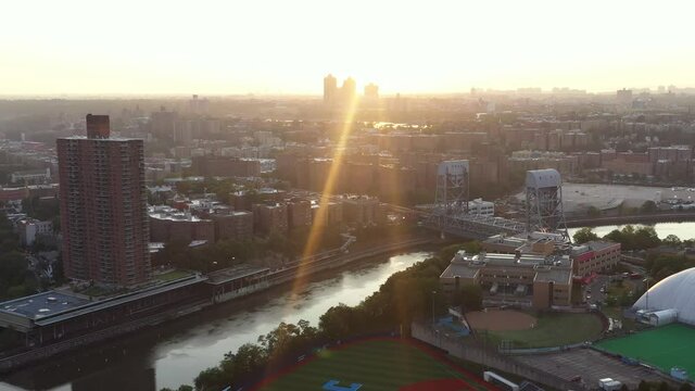 Aerial trucking flight towards the South Bronx New York City at sunrise with a huge lens sun flare