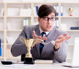 Businessman with golden cup in the office