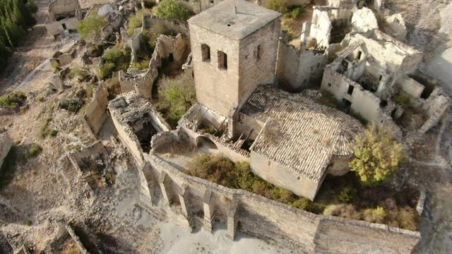 Ancient church in a desert mountainous landscape. Abandoned village of Esc&oacute; in Huesca, Spain. Dolly out aerial footage