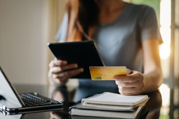 Obraz premium Woman hands using smartphone and holding credit card with digital layer as Online shopping concept.