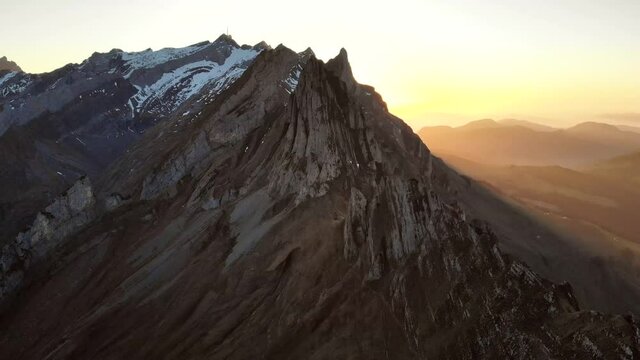 Aerial flyover over the cliffs of Schaefler in Appenzell, Switzerland at sunset with reverse motion