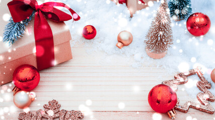 Xmas background table. Winter wooden decoration backdrop. Christmas board with old rustic wall, white frozen snow, golden balls and gift box. New year red bow present.