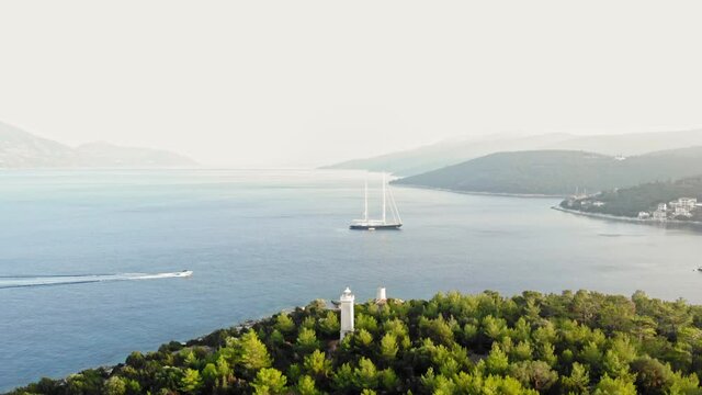 Panoramic View On Idyllic Seascape, yacht and Lighthouse Of Fiskardo In Kefalonia, Greece - drone shot