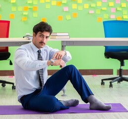 Man in the office with many conflicting priorities doing exercis