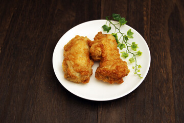 木製テーブルにある皿の上のフライドチキン