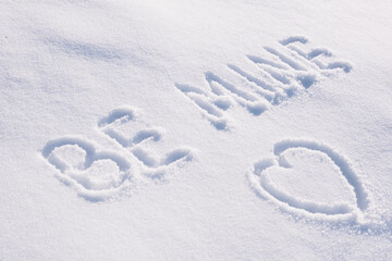 Text Be mine and contour drawing in shape of heart on white snow.