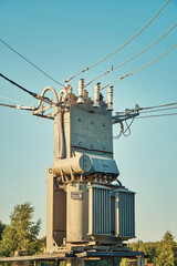 Fototapeta na wymiar Power transformer with insulators and cables under blue sky