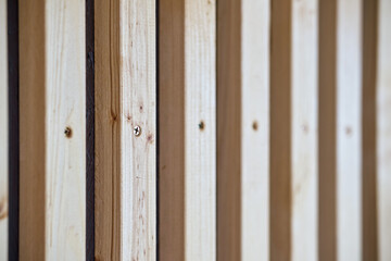Building wall decorated with stylish wooden furring made of thin light planks on house terrace extreme close view