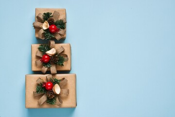 Stack of gift boxes in the form of Christmas tree on light blue background. Top view with copy space. Celebration Christmas or New year concept. Flat lay.
