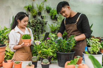 Asian young gardener couple use laptop in green house