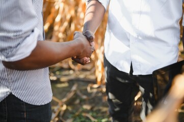Two African farmer partners shaking hands. The concept of agribusiness