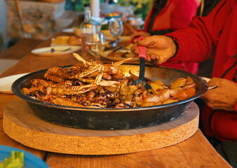 Octopus and shrimps with potatoes in metal pan ready to eat