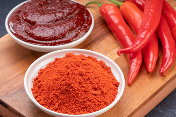 Korean pepper paste, chili powder and red pepper in wooden plate, Gochujang Korean traditional Chili paste on a wooden table background.