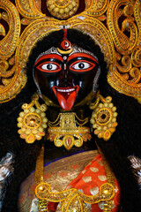 Idol of Goddess Maa Kali at a decorated puja pandal in West Bengal, India. Kali puja is a famous...