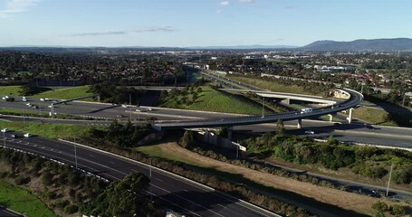 Slow tracking and accent camper van and truck pulling boat along highway interchange arterial on a typical summers afternoon.